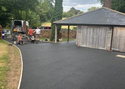 Contractors installing black resin bound driveway at a period property in the Bedfordshire countryside