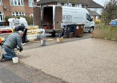 Workers installing resin-bound driveway surface