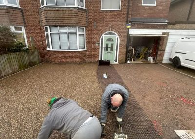 Workers applying resin on driveway