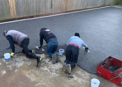 Workers applying resin driveway surface