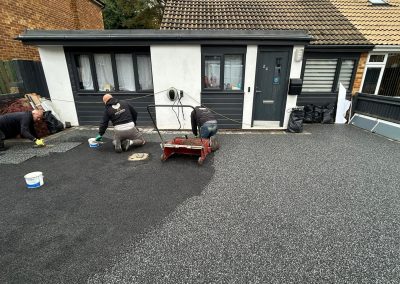 Workers applying resin on driveway