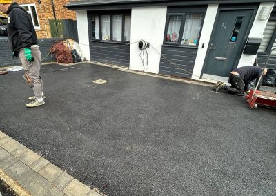 Workers applying resin on driveway