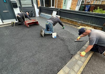 Workers applying resin on driveway