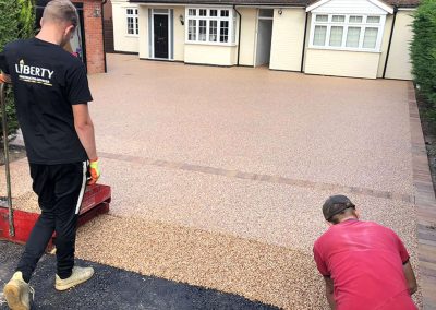 Workers applying resin driveway surface
