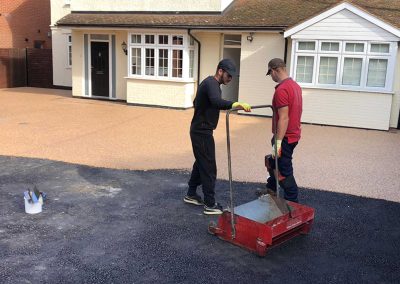 Workers applying resin driveway surface