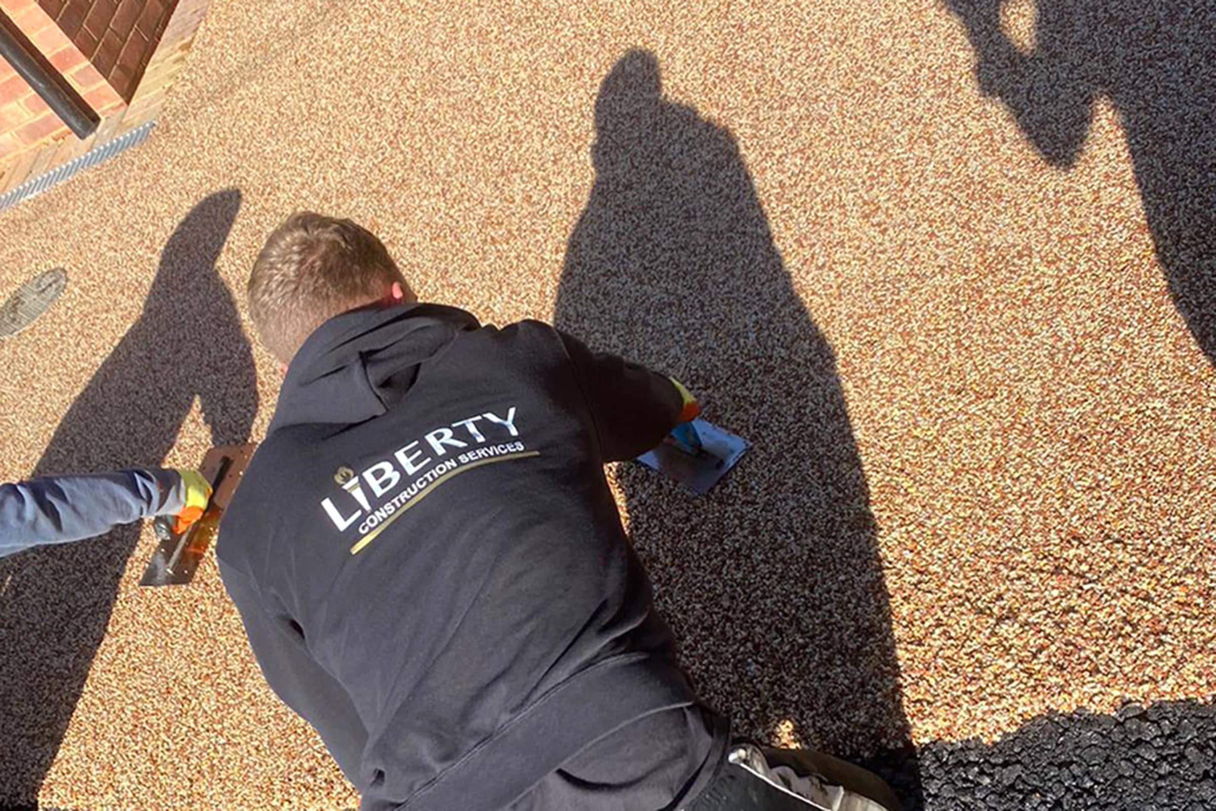 Workers applying resin driveway surface