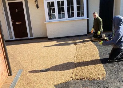 Workers applying resin driveway surface