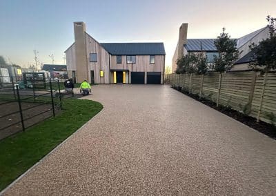 Worker applying resin driveway surface