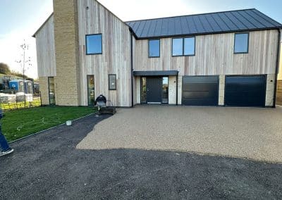 Worker applying resin driveway surface