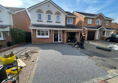 Workers applying resin driveway surface