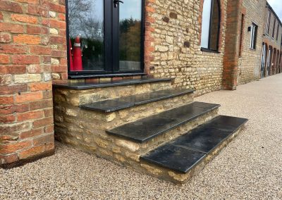 Stone steps leading to a door and resin bound driveway