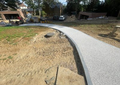 Curved resin pathway under construction in garden