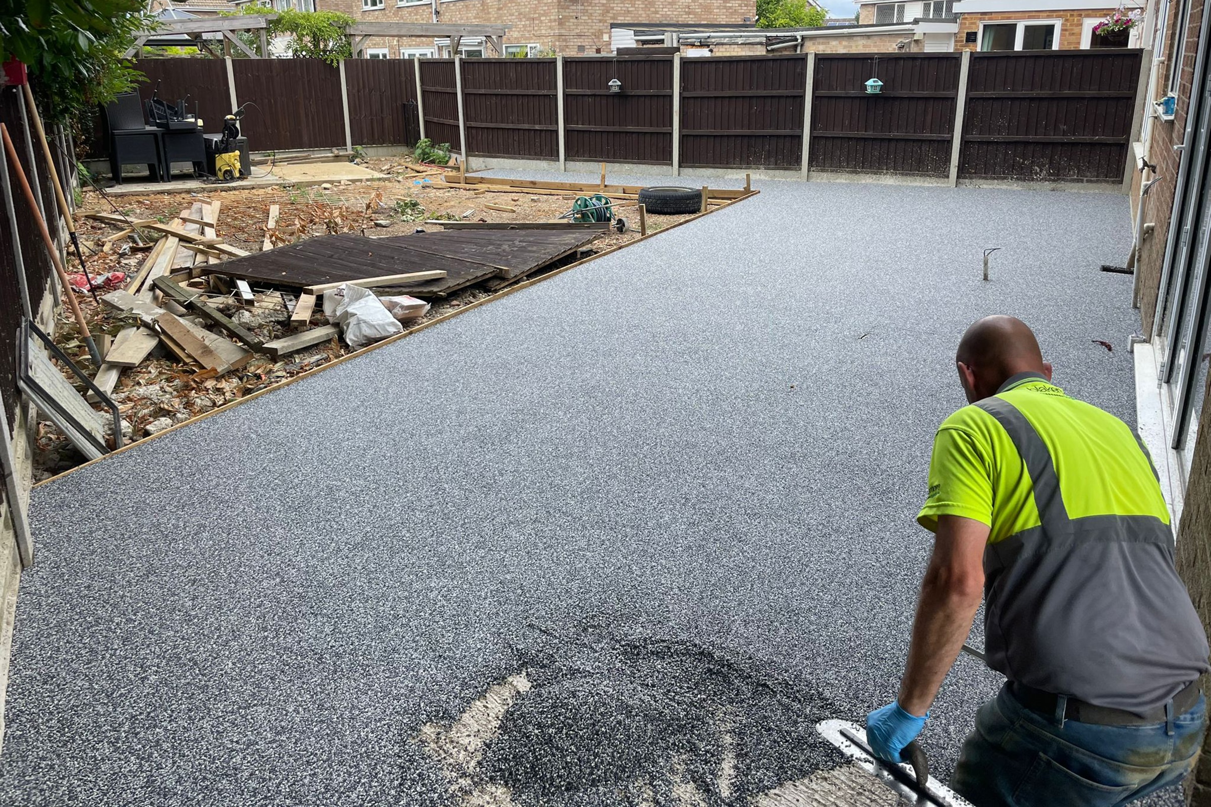 Worker applying resin on patio