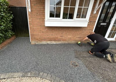 Worker applying resin driveway surface