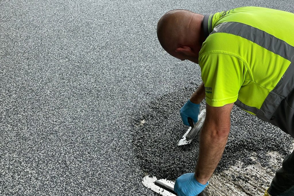 Worker applying resin bound surface material