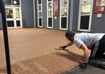 Worker applying resin driveway surface